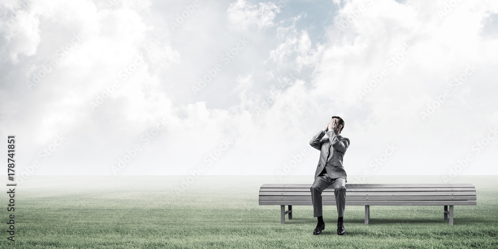 Young man in summer park on bench do not want to see anything Young man in summer park on bench do not want to see anything