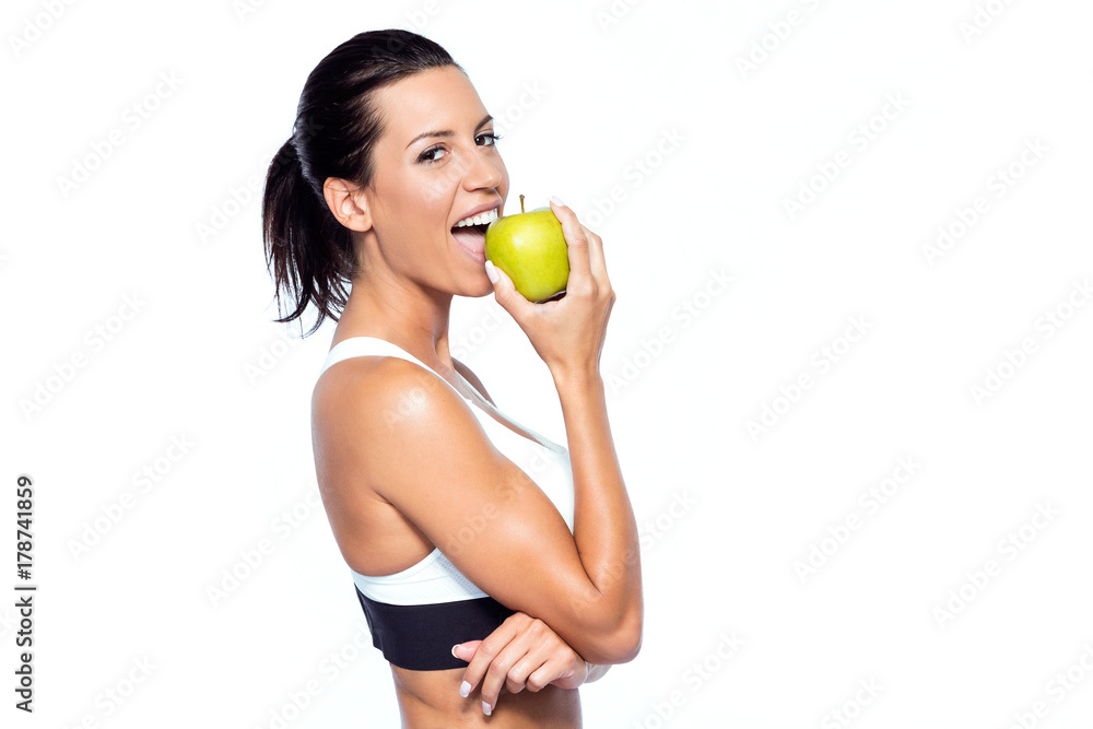 Beautiful young woman eating an apple over white background. Beautiful young woman eating an apple over white background.