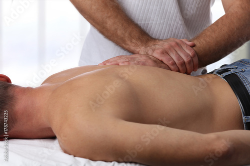 Man having chiropractic back adjustment. Osteopathy  Physiotherapy  sport injury rehabilitation concept