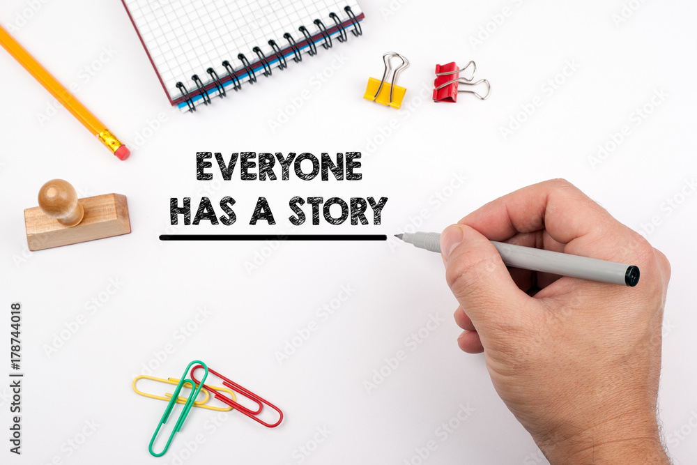 Everyone Has a Story. White office desk on which various items Everyone Has a Story. White office desk on which various items