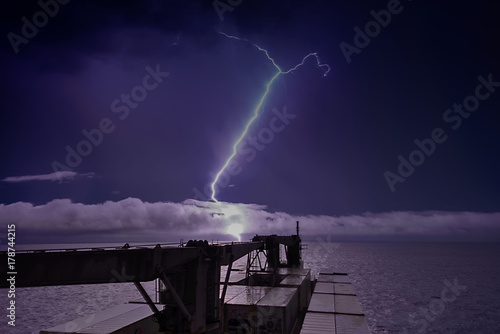 Thundertorm in sea with lightnings in sky and ship