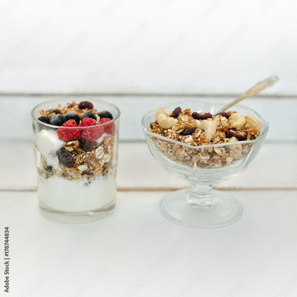 Granola with berries and yogurt on a white background. Traditional American Breakfast Granola with berries and yogurt on a white background. Traditional American Breakfast