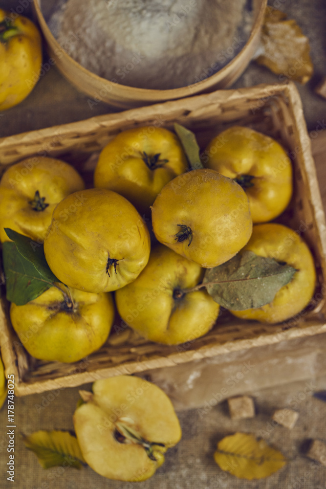 A lot of apple quince with kitchenware, preparing for quince pie on sackcloth rustic background. top view. A lot of apple quince with kitchenware, preparing for quince pie on sackcloth rustic background. top view.