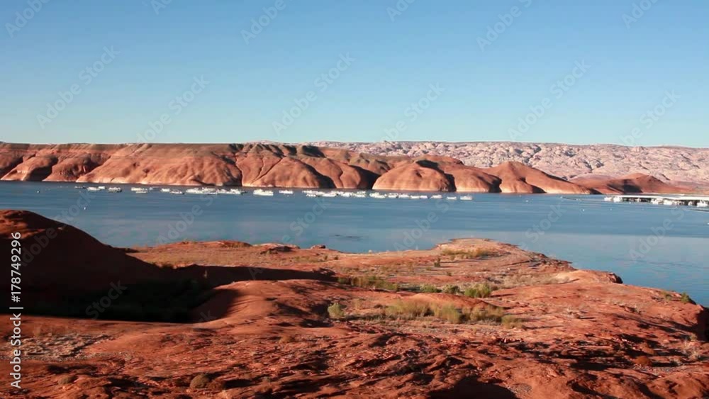 A landscape view of a lake boat harbor. The beautiful red rocks make the perfect contrast with the blue sky. A landscape view of a lake boat harbor. The beautiful red rocks make the perfect contrast with the blue sky.