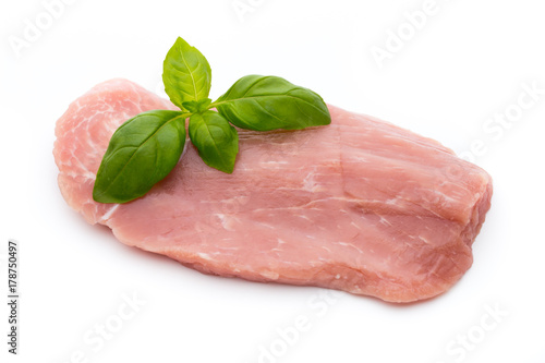 Fresh pork fillet with basil on a white background.