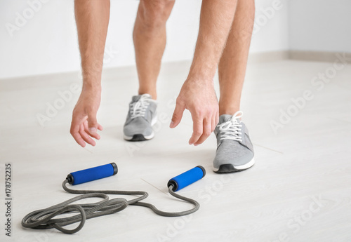 Young man with jumping rope indoors