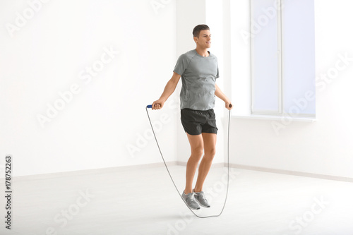 Konstfotografi Young man skipping rope indoors