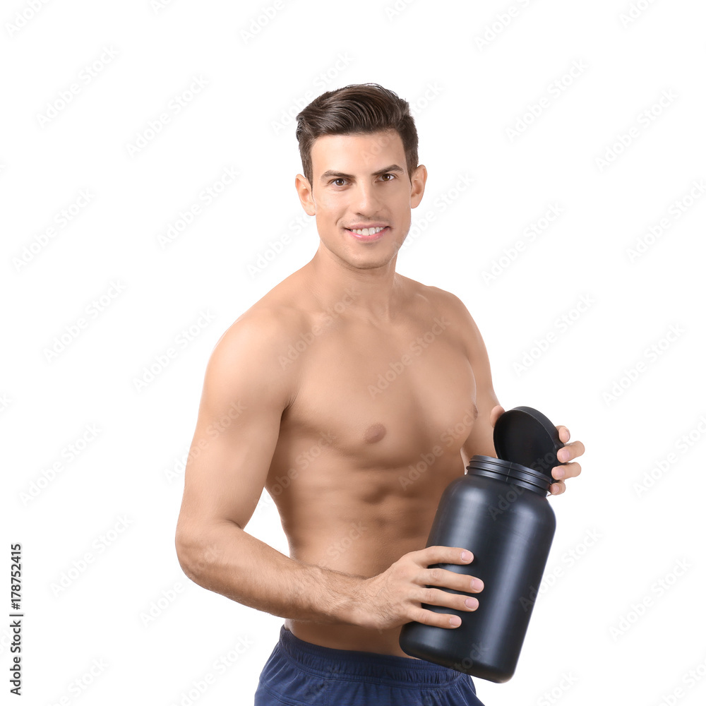 Shirtless young man holding black jar with protein powder on white background Shirtless young man holding black jar with protein powder on white background