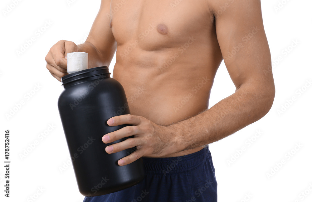 Naklejka premium Shirtless young man holding black jar with protein powder on white background
