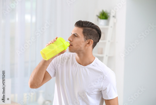 Young man drinking protein ...