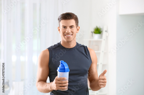 Young man holding bottle wi...