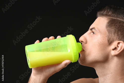 Young man drinking protein ...