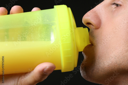 Young man drinking protein ...