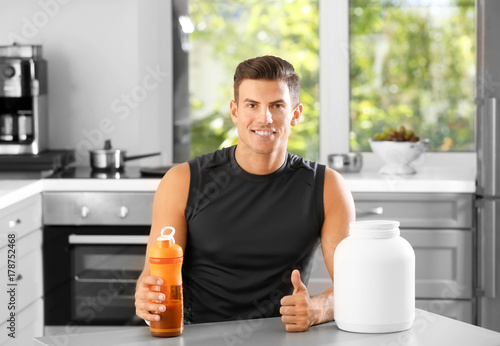 Young man holding bottle wi...