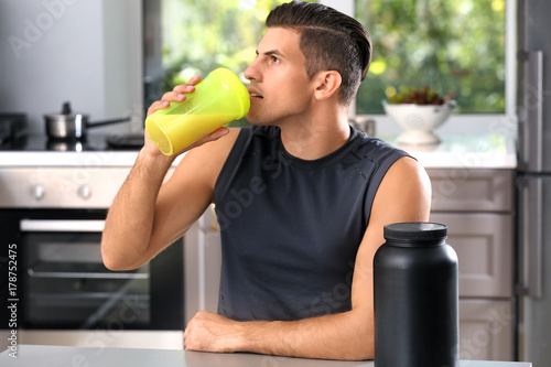 Young man drinking protein ...