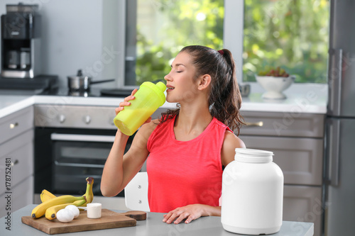 Young woman drinking protei...