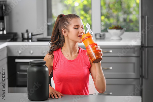 Young woman drinking protei...