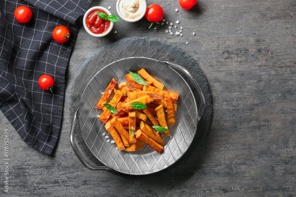 Pan with sweet potato fries on table