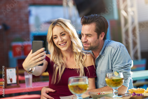 romantic couple taking selfies at mexican taco restaurant