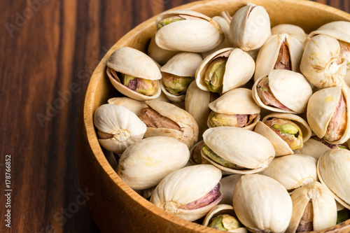Pistachio nuts on wooden rustic bowl