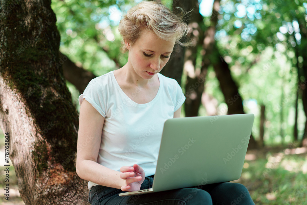 woman at the computer in the woods woman at the computer in the woods