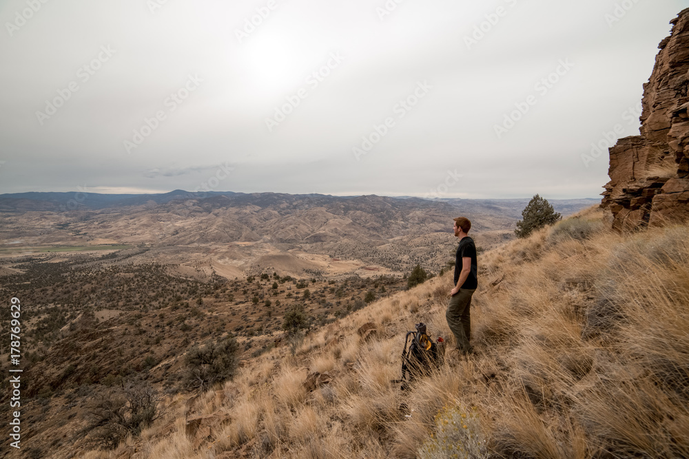 Tall young man on mountainside while Backpacking near the Painted Hills