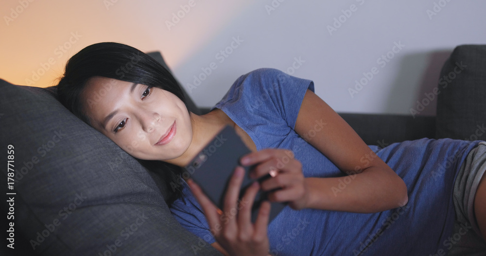 Woman use of mobile phone and lying on sofa Woman use of mobile phone and lying on sofa