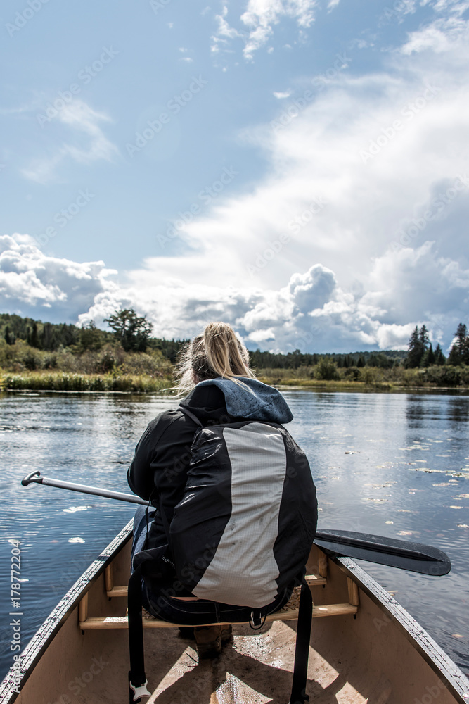 Girl canoeing with Canoe on the lake of two rivers in the algonquin national park in Ontario Canada on sunny cloudy day Girl canoeing with Canoe on the lake of two rivers in the algonquin national park in Ontario Canada on sunny cloudy day