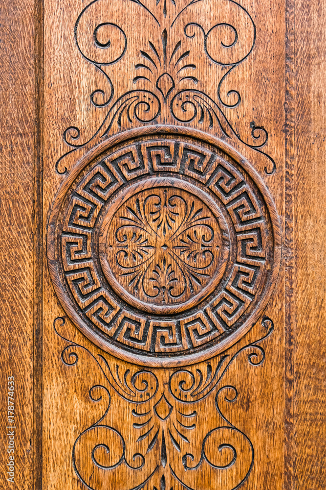 Obraz premium Embossed round ornament on a brown wooden surface