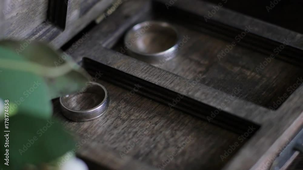 wedding rings lie in a wooden box. wedding bouquet on the background of rings. slow motion wedding rings lie in a wooden box. wedding bouquet on the background of rings. slow motion