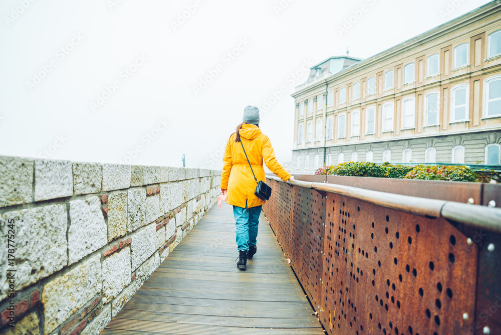 woman walking by tourist place in autumn day
