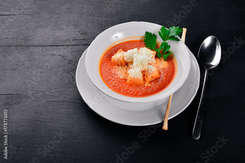 Tomato soup. On a wooden surface. Top view. Free space for your text.