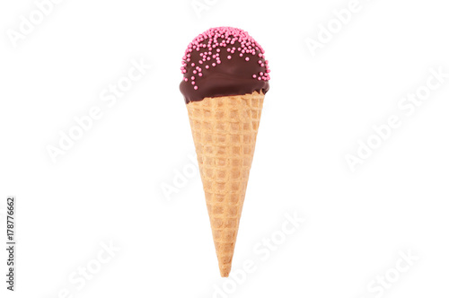 Chocolate cake pop in waffle cone for ice cream, decorated with pink confectionery sprinkles. Isolated. Picture for a menu or a confectionery catalog.