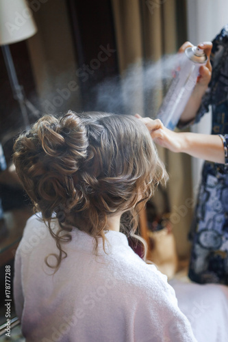 Young bride preparing for wedding, making hairstyle at home in the morning