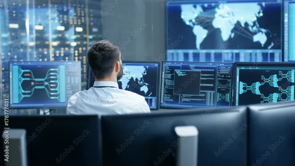 Back View in the System Control Center Operator Working. Multiple Screens Showing Technical Data. Shot on RED EPIC-W 8K Helium Cinema Camera. Back View in the System Control Center Operator Working. Multiple Screens Showing Technical Data. Shot on RED EPIC-W 8K Helium Cinema Camera.