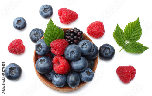 mix of blueberries, blackberries, raspberries in wooden bowl isolated on white background. top view