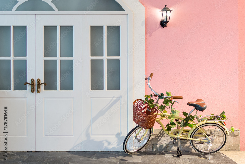 Yellow bicycle parking at front of white door.