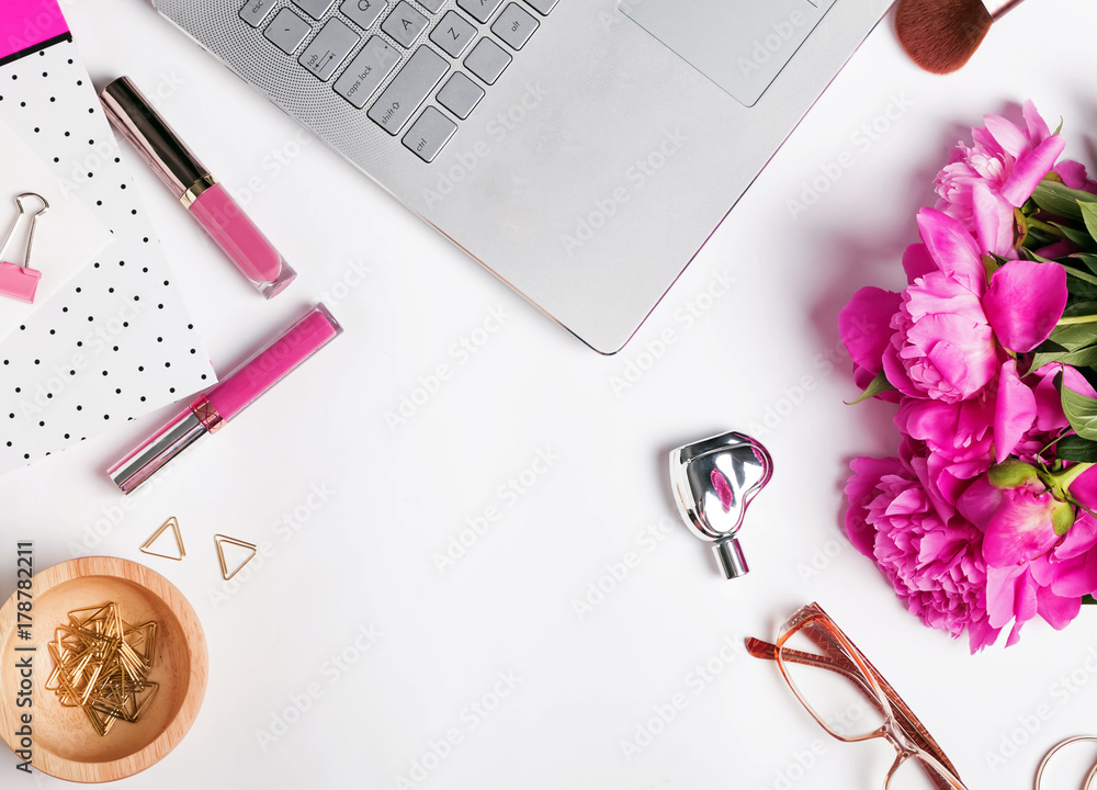 Feminine workplace with laptop and flowers Feminine workplace with laptop and flowers
