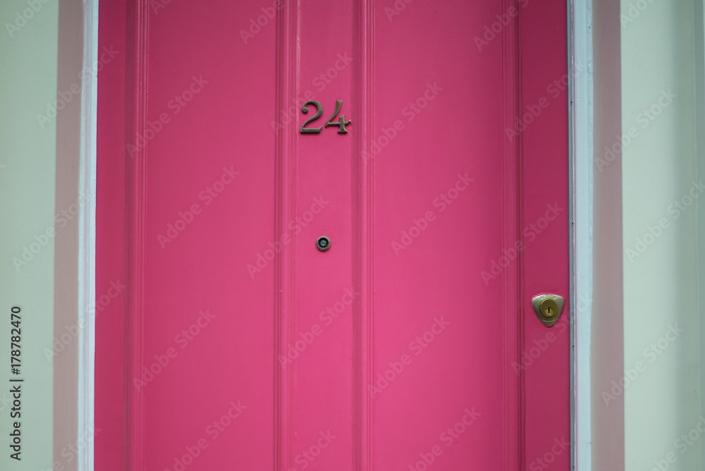 Door number 24 (twenty four). Metal plate on pink wooden door Door number 24 (twenty four). Metal plate on pink wooden door