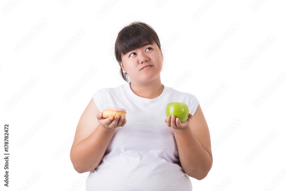 Fat asian woman wearing white t-shirt and choosing to eat green apple or donut isolated on white. Food and Healthcare concept Fat asian woman wearing white t-shirt and choosing to eat green apple or donut isolated on white. Food and Healthcare concept
