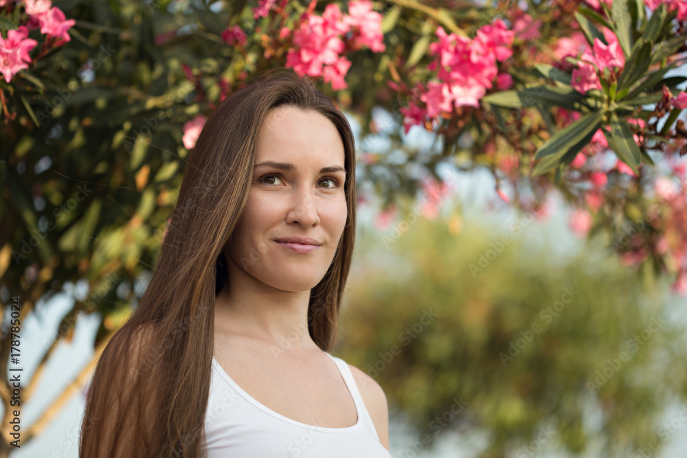 Smiling woman against blurred flower backdrop Smiling woman against blurred flower backdrop