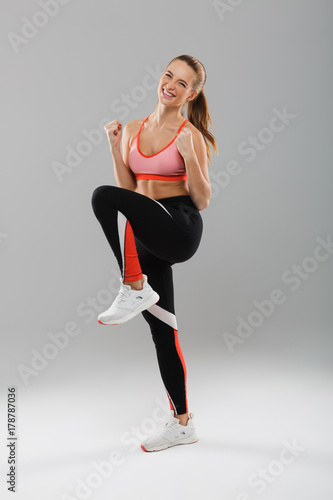 Full length portrait of a smiling happy sportsgirl celebrating success