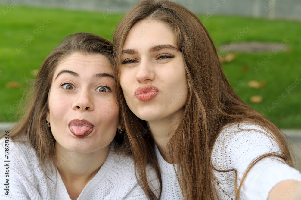 Two friends show their tongue while making a selfie photo Two friends show their tongue while making a selfie photo