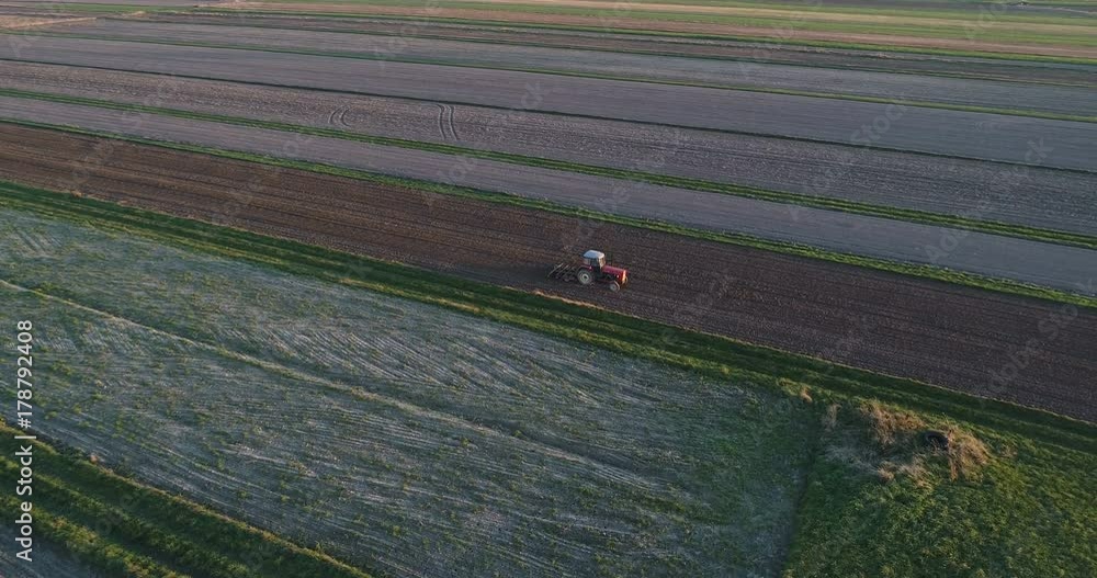 Aerial drone view of tractor plowing field at autumn Aerial drone view of tractor plowing field at autumn