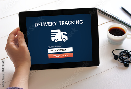 Hand holding tablet with delivery tracking concept on screen. All screen content is designed by me