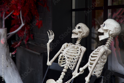 Halloween outdooe decor skeletons hanging out at the porch