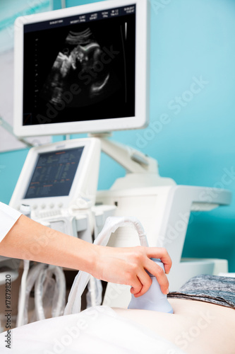 Doctor performing obstetric ultrasonography on a pregnant woman