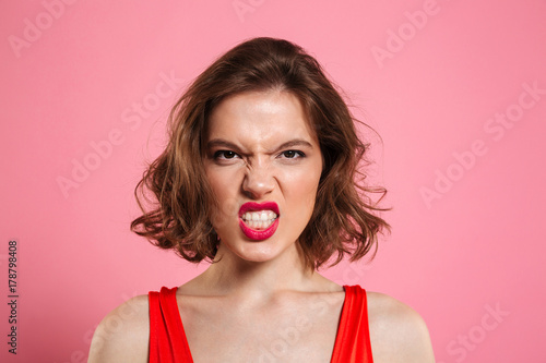 Canvas Print Close-up portrait of angry young woman with red lips looking at camera