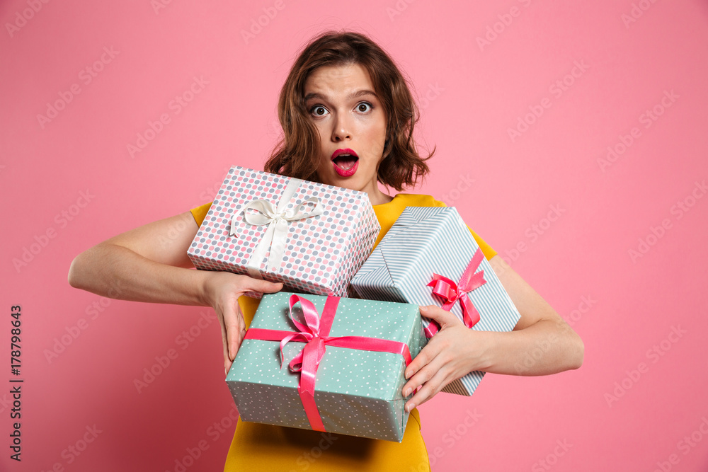 Close-up portrait of amazed beautiful woman holding bunch of presents, looking at camera Close-up portrait of amazed beautiful woman holding bunch of presents, looking at camera