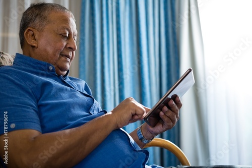 Low angle view of senior man using digital tablet in nursing